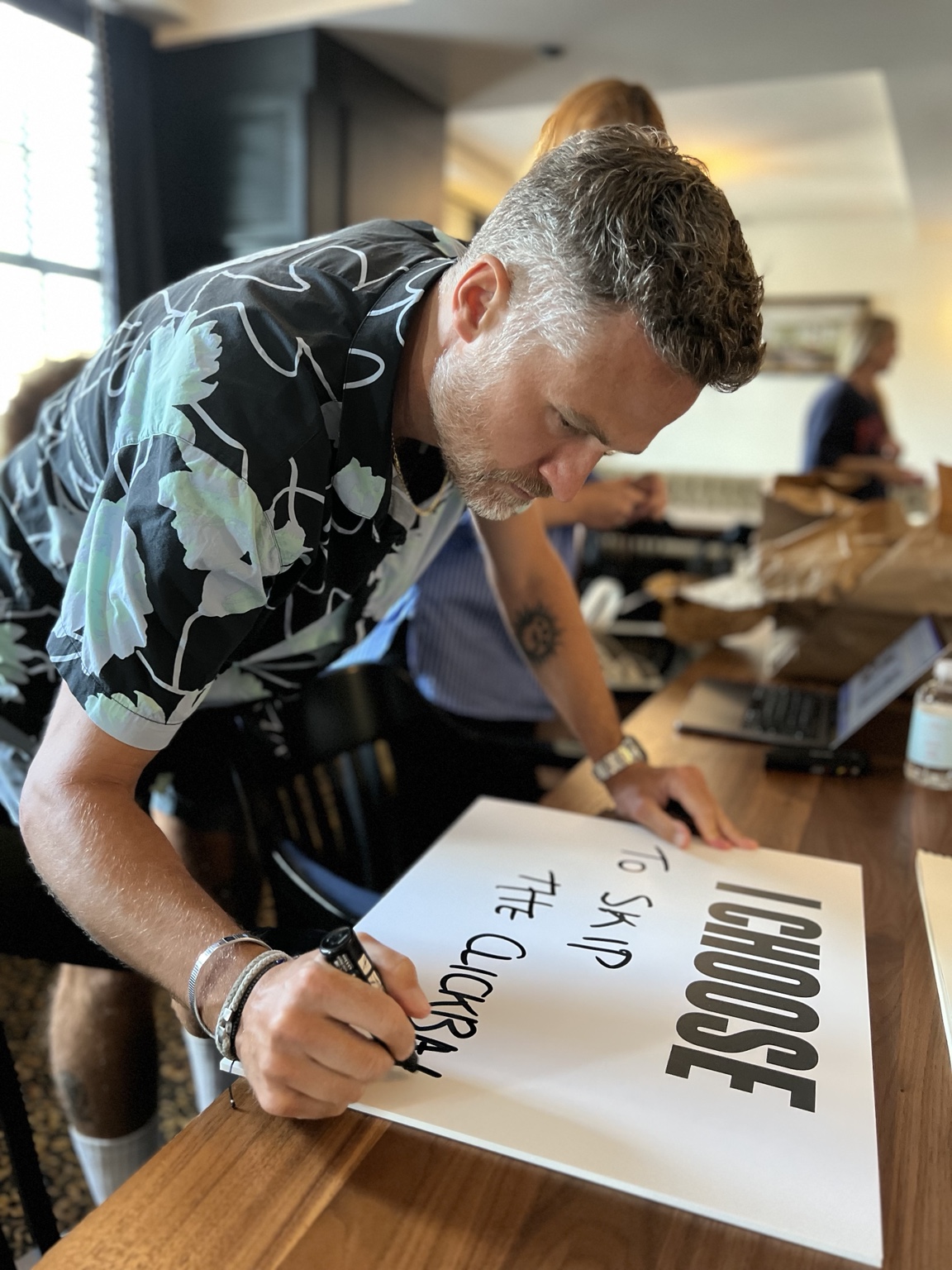 Milan writing on an I CHOOSE card during All We Share production.